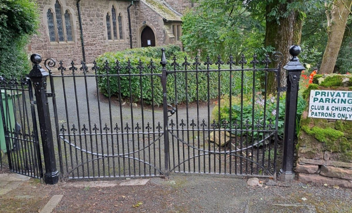 A black iron fence outside a church yard