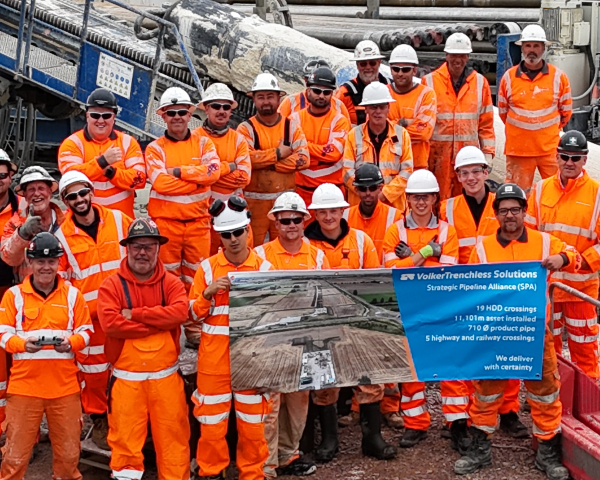 Team photo of people in orange high vis holding a banner.