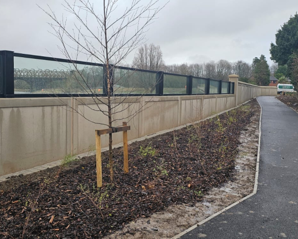 Glass flood panels a top a concrete wall by a river